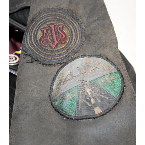 119 - Vintage leather motorbike jacket with a collection of metal badges to include gollies. pit to pit ac... 