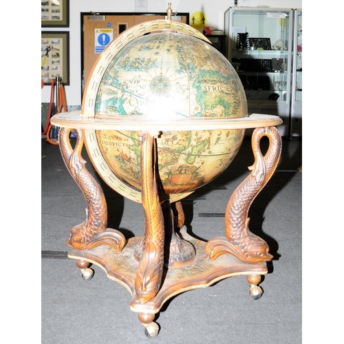 552 - Globe high top drinks cabinet standing on a turned center support with carved Dolphins to each corne... 