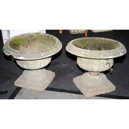 245 - A pair of vintage reconstituted concrete garden urns. One requires restoration.