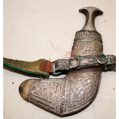 138 - Vintage ornate ceremonial Arab Jambiya double edged curved dagger and belt in a silver sheath.