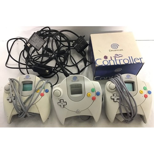 444 - SEGA DREAMCAST CONTROLLERS. A total of 3 hand held devices here with a collection of Rf converter ca... 