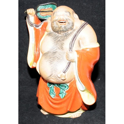 437 - Large vintage pottery figure of a laughing buddha with a fan. 21cms tall. Unsigned.