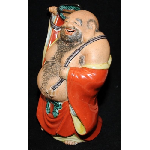 437 - Large vintage pottery figure of a laughing buddha with a fan. 21cms tall. Unsigned.