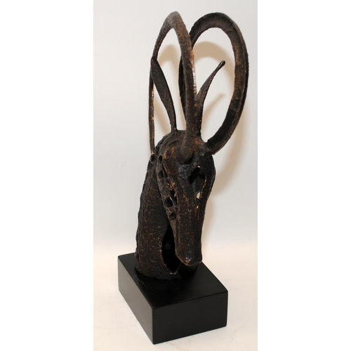 289 - Modernist cast metal sculpture of a horned animal's head. 37cms tall including plinth