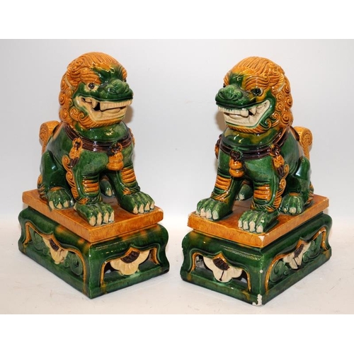 16 - Pair of large ceramic Dogs of Fo in green/orange glaze. 34cms tall