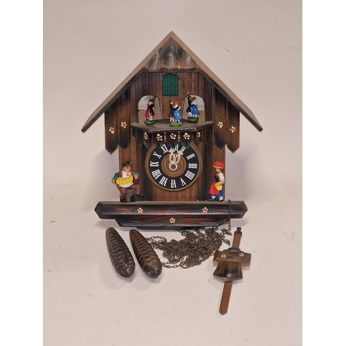 298 - A black forest style wooden cuckoo clock with weights and pendulum.