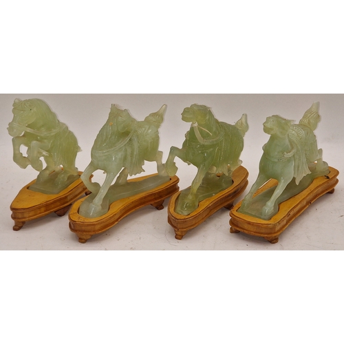 35 - Four Oriental jade style figures of horses each with wooden stands.