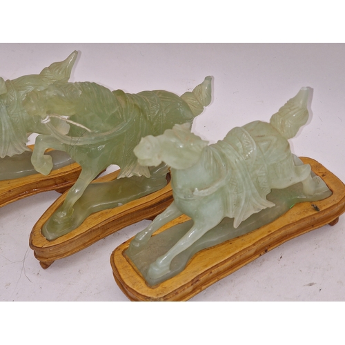 35 - Four Oriental jade style figures of horses each with wooden stands.