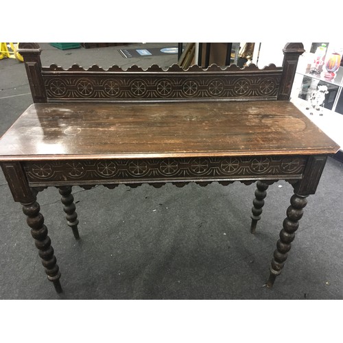 425 - Oak stained hall table set on turned supports with carved under and back tray, having secret draws t... 