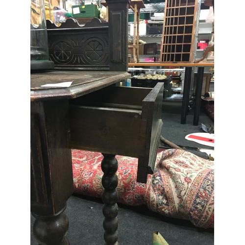 425 - Oak stained hall table set on turned supports with carved under and back tray, having secret draws t... 