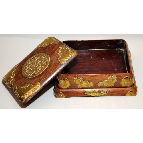 31 - Oriental hardwood lidded box on a separate base with applied brass decoration. 15cms across