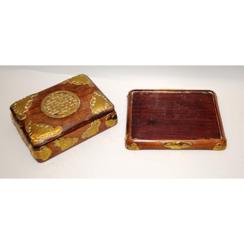 31 - Oriental hardwood lidded box on a separate base with applied brass decoration. 15cms across