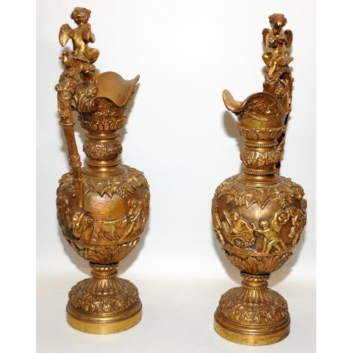 139 - A pair of large antique neoclassical bronze gilt candle stands in the form of ewers. 58cms tall