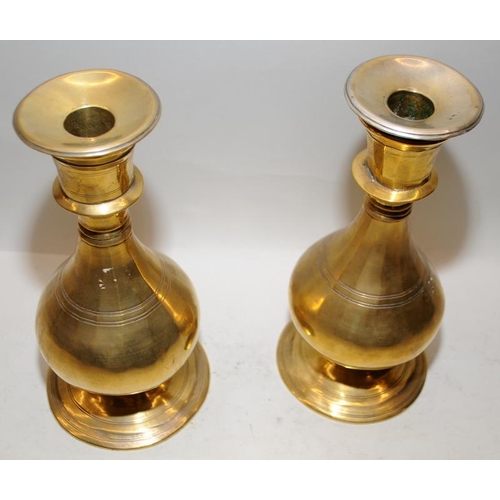 169 - A pair of brass candlesticks of baluster form. 23cms tall