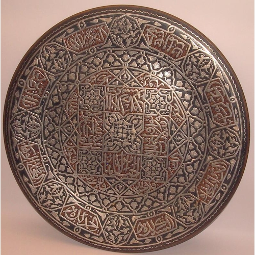 52 - Large Eastern copper charger with extensive applied silver decoration. 51.5cms across