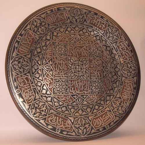 52 - Large Eastern copper charger with extensive applied silver decoration. 51.5cms across