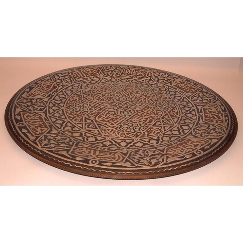 52 - Large Eastern copper charger with extensive applied silver decoration. 51.5cms across