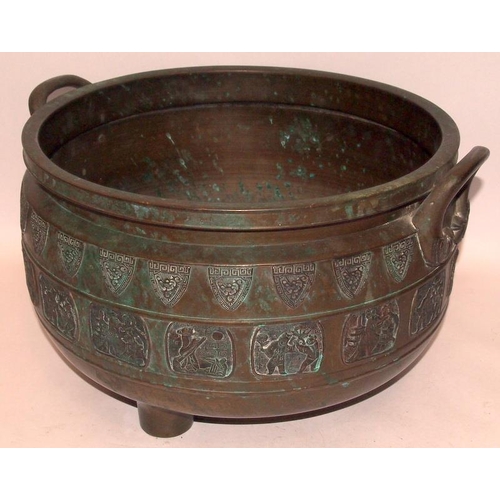 25 - A large bronze twin handled incense burner with exterior decoration of dragon shields and various Or... 