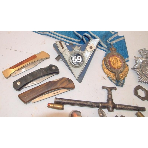 58 - A box of collectibles including penknives, car and police badges etc