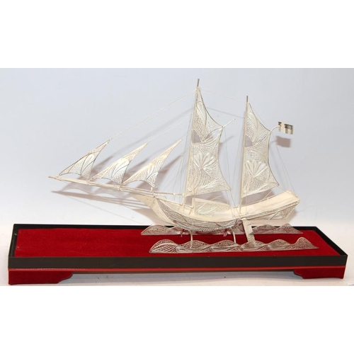 227 - Silver filigree model of a twin masted ship under full sail in a glass presentation case. O/all case... 