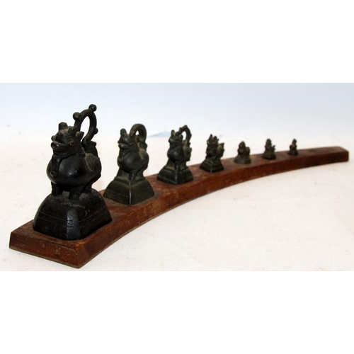 289 - Set of antique Burmese bronze opium weights in the form of mythical beasts on a wooden stand (larges... 