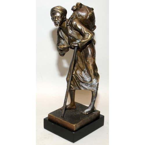 22 - PL Kamrollez: Small bronze of an Arab water seller with a stick. Signed. 24cms tall