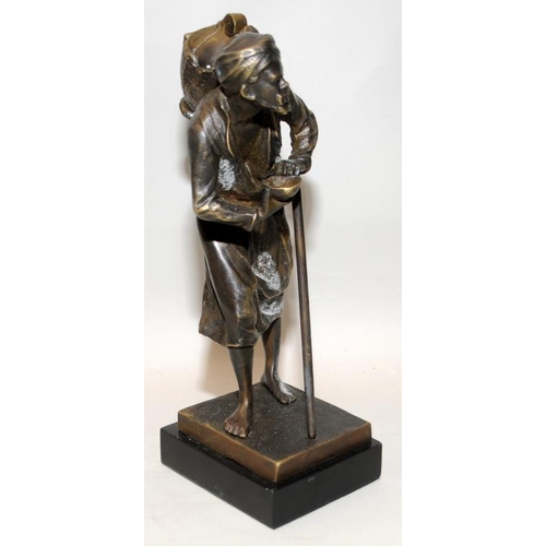 22 - PL Kamrollez: Small bronze of an Arab water seller with a stick. Signed. 24cms tall