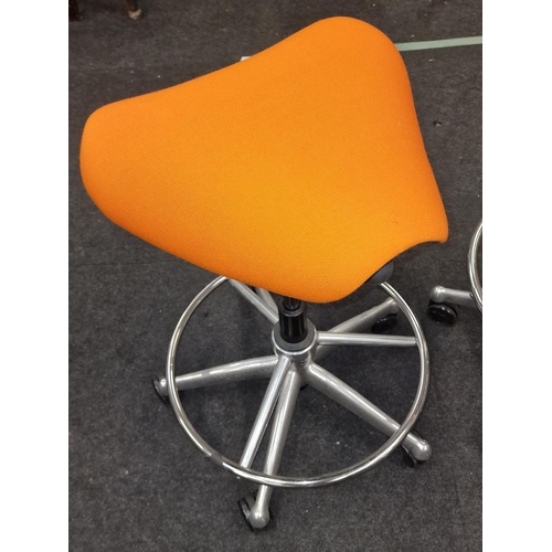 245 - A pair of contemporary gas lift swivel saddle seats on chrome bases with orange upholstery.