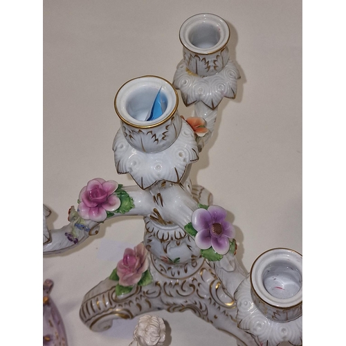 24 - Ornate Continental candlestick together with a pair of bisque wall plaques, and small figure (4)