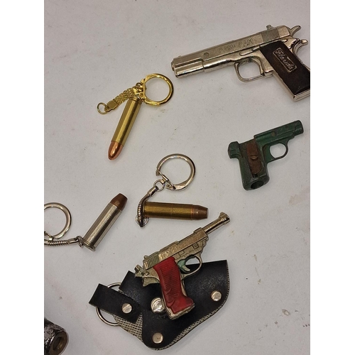 84 - A collection of novelty gun and bullet related items, keyrings etc together with a 