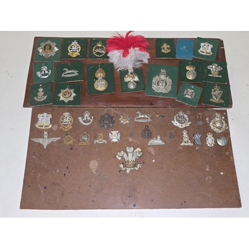 A collection of vintage military regimental badges attached to two boards.