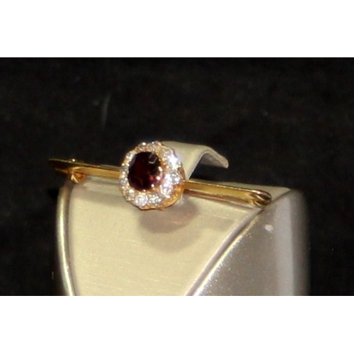231 - Vintage tested gold bar brooch featuring a garnet surrounded by diamonds. 4g
