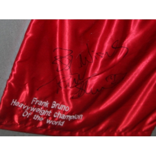 11 - Frank Bruno signed Heavyweight Champion of the World red boxing shorts.  Framed with associated phot... 