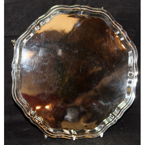 318 - Large and heavy solid silver platter on scroll feet with scalloped border. Hallmarked for Sheffield ... 