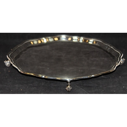 318 - Large and heavy solid silver platter on scroll feet with scalloped border. Hallmarked for Sheffield ... 