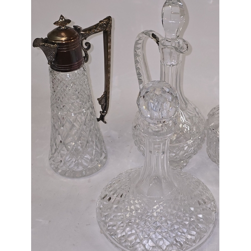 21 - A collection of quality crystal glass decanters to include one with low grade continental silver col... 