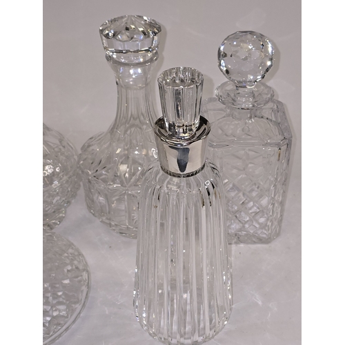21 - A collection of quality crystal glass decanters to include one with low grade continental silver col... 