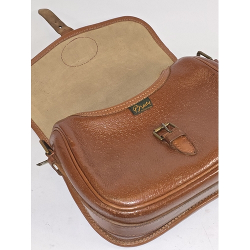 22 - A vintage Brady brown pigskin leather cartridge bag. Includes strap. Good condition for age.