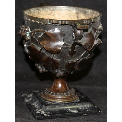 26 - Antique bronze chalice with foliate decoration mounted on a marble plinth. O/all 19cms tall