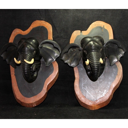 42 - A pair of vintage carved ebony elephant head wall plaques. 36cms tall