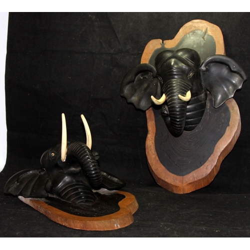 42 - A pair of vintage carved ebony elephant head wall plaques. 36cms tall