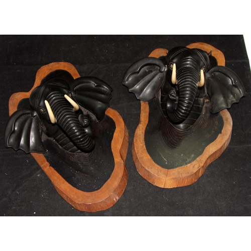 42 - A pair of vintage carved ebony elephant head wall plaques. 36cms tall
