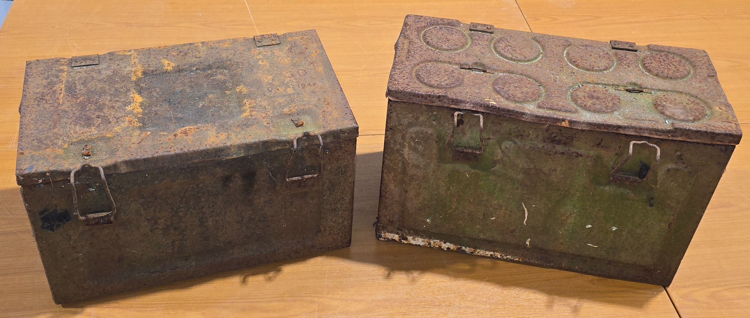 A pair of vintage metal ammunition boxes.