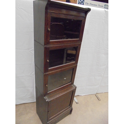 710 - OAK GLAZED 3 DOOR BOOKCASE ON CUPBOARD BASE