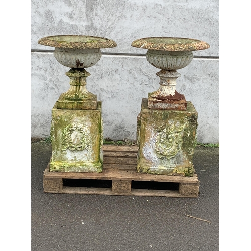 2 - LARGE CAST URNS ON TERRACOTTA PLINTHS