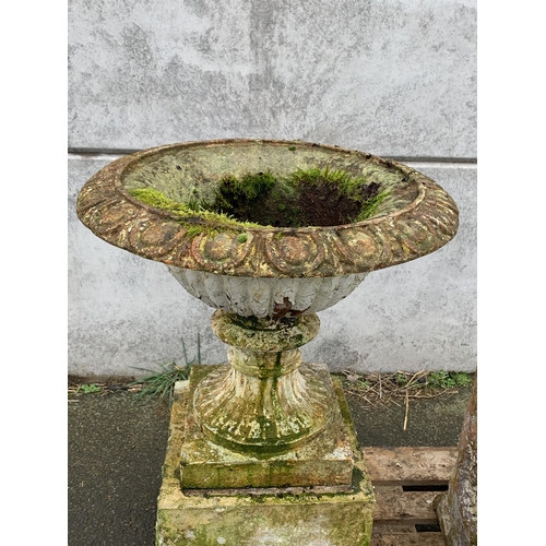 2 - LARGE CAST URNS ON TERRACOTTA PLINTHS