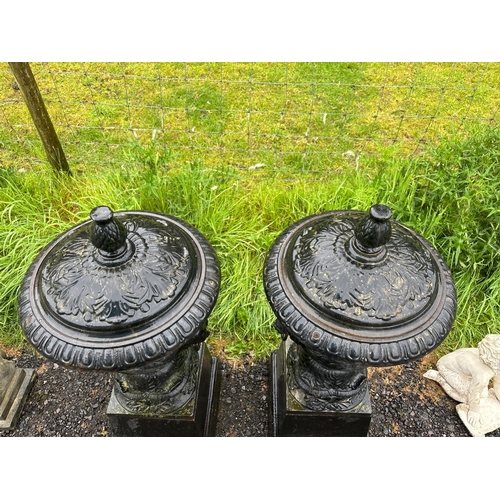 45 - PAIR OF LARGE CAST URNS ON PLINTHS