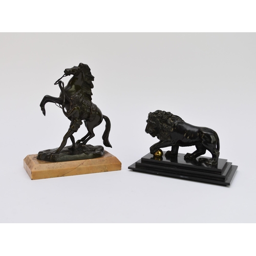 503 - A bronze model of a lion, late 19th century, modelled standing with front paw resting on a ball, set... 