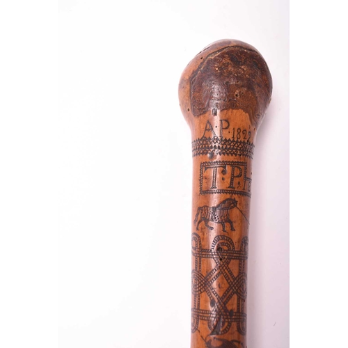 401 - A 19th century incised cane, likely of Colonial Indian origin, the tapering shaft with natural knot ... 