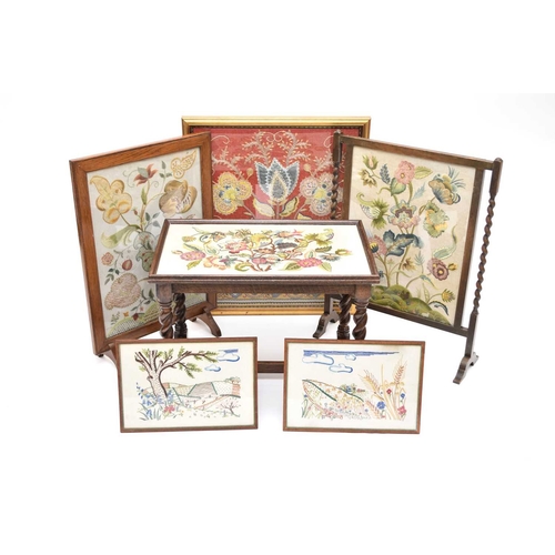 426 - Two early 20th century oak fire screens inset with woolwork embroideries of flowers and foliage, 53c... 